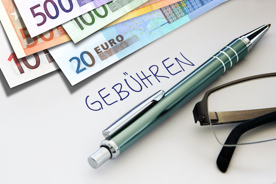 Banknotes and handwritten word ‘Gebühren’ in German, meaning costs